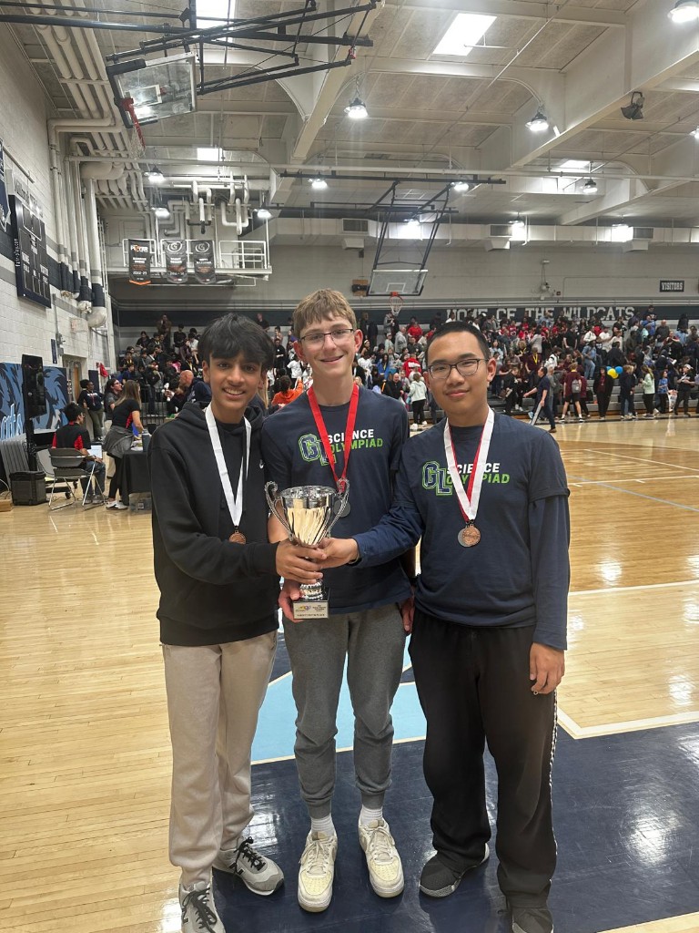 Me and fellow captains holding a trophy in the gym after a Science Olympiad competition