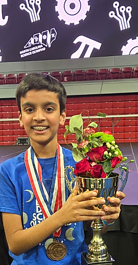 Holding a trophy and medal at North Carolina Science Olympiad for Davis Drive Middle School